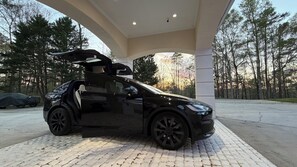 A black car parked under a white structure with a paved ground. - This beautiful Luxury Mini Mansion,  4 bedroom 4 bath estate in Atlanta GA. (Atlanta)