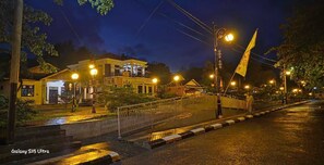 A nighttime street scene with a building, streetlights, and a flag. - D' Kabong SIRIH Homestay (Bandanaira)