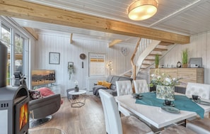A modern living room with a fireplace, a dining area, and a staircase. - 3 bedroom awesome home in Wandlitz (Wandlitz)