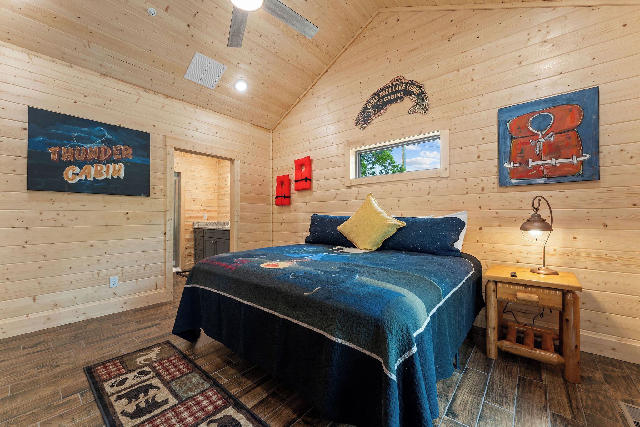 Interno di una cabina con un letto, un comodino, una finestra e un cartello che indica che si tratta di una cabina del Table Rock Lake Lodge.