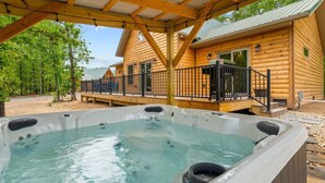 Une cabane en bois avec un jacuzzi et une terrasse.