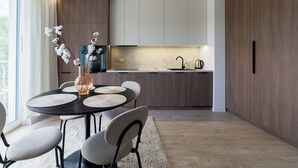 Eine moderne Küche mit Holzschränken, eine Essecke mit rundem Tisch und Stühlen sowie eine Vase mit Blumen.