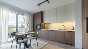 Eine moderne Küche mit Essbereich, großen Fenstern und Blick auf die Stadt.