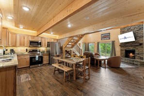A wooden cabin interior with a kitchen, dining area, and fireplace. - True Log Cabin Near Thunder Ridge & Big Cedar_Pvt Hot Tub_Free Attraction Tickets_Bonus Loft (Ridgedale)