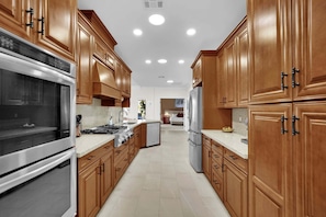 A modern kitchen with wooden cabinets, stainless steel appliances, and a central island.
