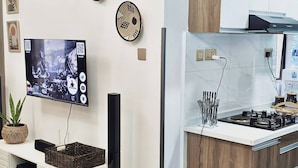 Una cucina moderna con piano cottura integrato, TV a schermo piatto e decorazioni a parete.