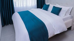Una camera d'albergo con un letto, tende e vista dalla finestra.