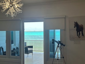 Ein Zimmer mit Teleskop, Stuhl und Blick auf den Ozean.