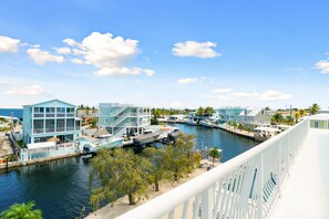 A marina with boats docked, a waterfront building, and a clear sky. - Dolphin Paradise: Pool, Elevator, Waterfront with Dock (Key Largo)
