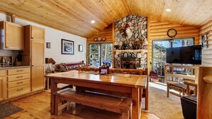 Un interior de madera con chimenea de piedra, muebles de madera y un televisor.