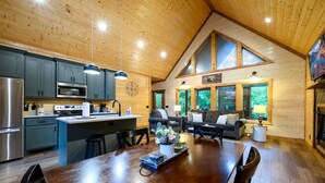 Un'ampia cucina con elettrodomestici moderni, una zona pranzo con tavolo in legno e un accogliente soggiorno con camino.