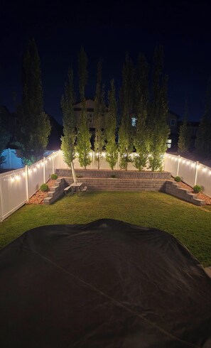 Ein Garten mit Zelt, Backsteinmauer und Holzbank.
