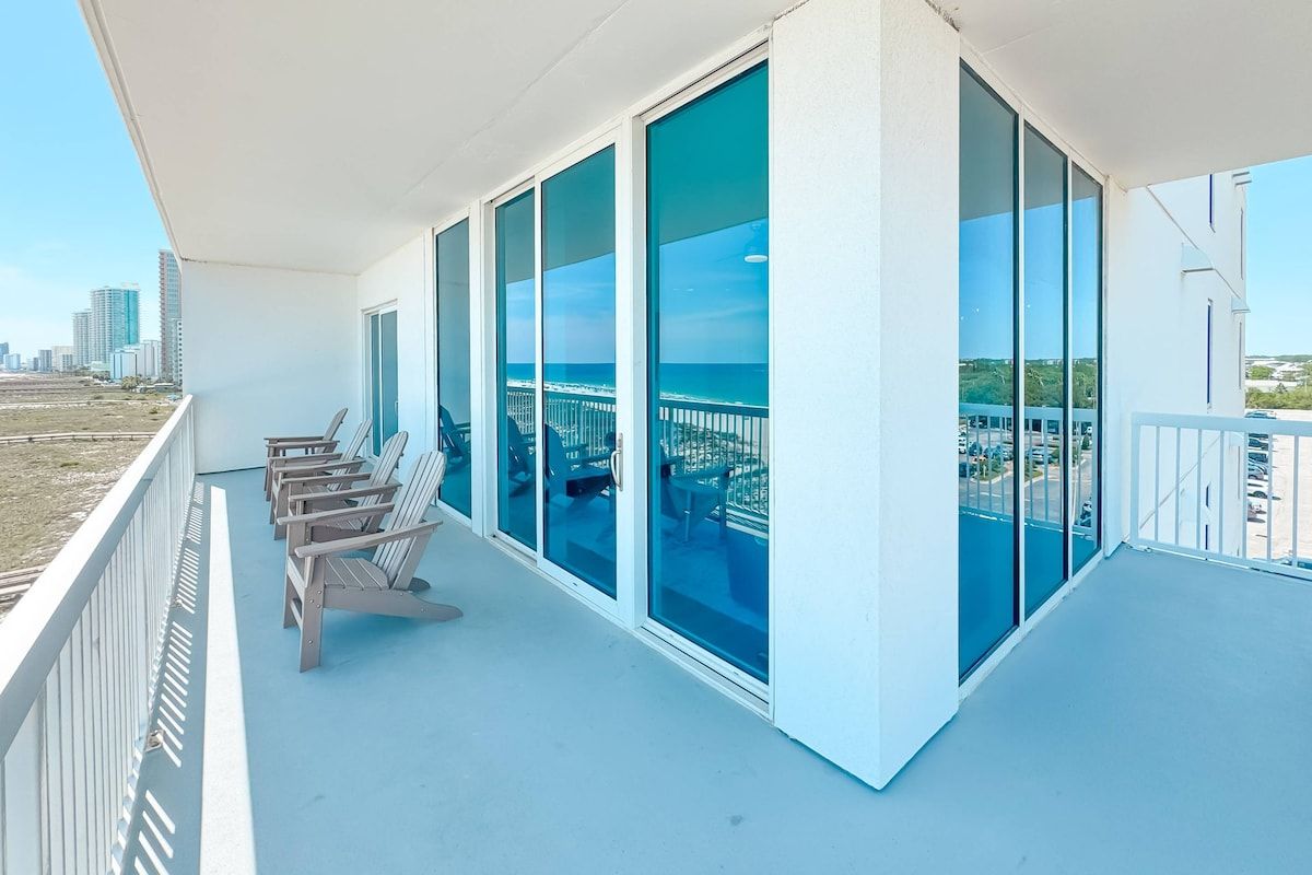 Un balcon avec vue sur l’océan et sur le paysage urbain.