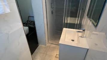 Deluxe driepersoonskamer | Badkamer | Een douche, gratis toiletartikelen, een haardroger, handdoeken