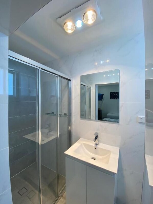 Habitación triple Deluxe, varias camas | Baño | Regadera, amenidades de baño gratuitas, secadora de cabello, toallas 
