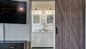 Une salle de bain avec un meuble-lavabo, un miroir et un lavabo équipé de trois lampes.