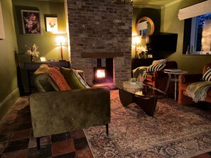 Una sala de estar acogedora con chimenea, asientos cómodos y un televisor.