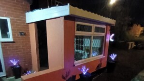Un edificio pequeño de un solo piso con una ventana, una puerta y un cartel que dice 'Le Hub'.