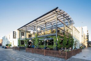 A building with a glass roof, outdoor seating, and greenery. - Spacious CBD Townhouse | Stadium + Parking (Christchurch)