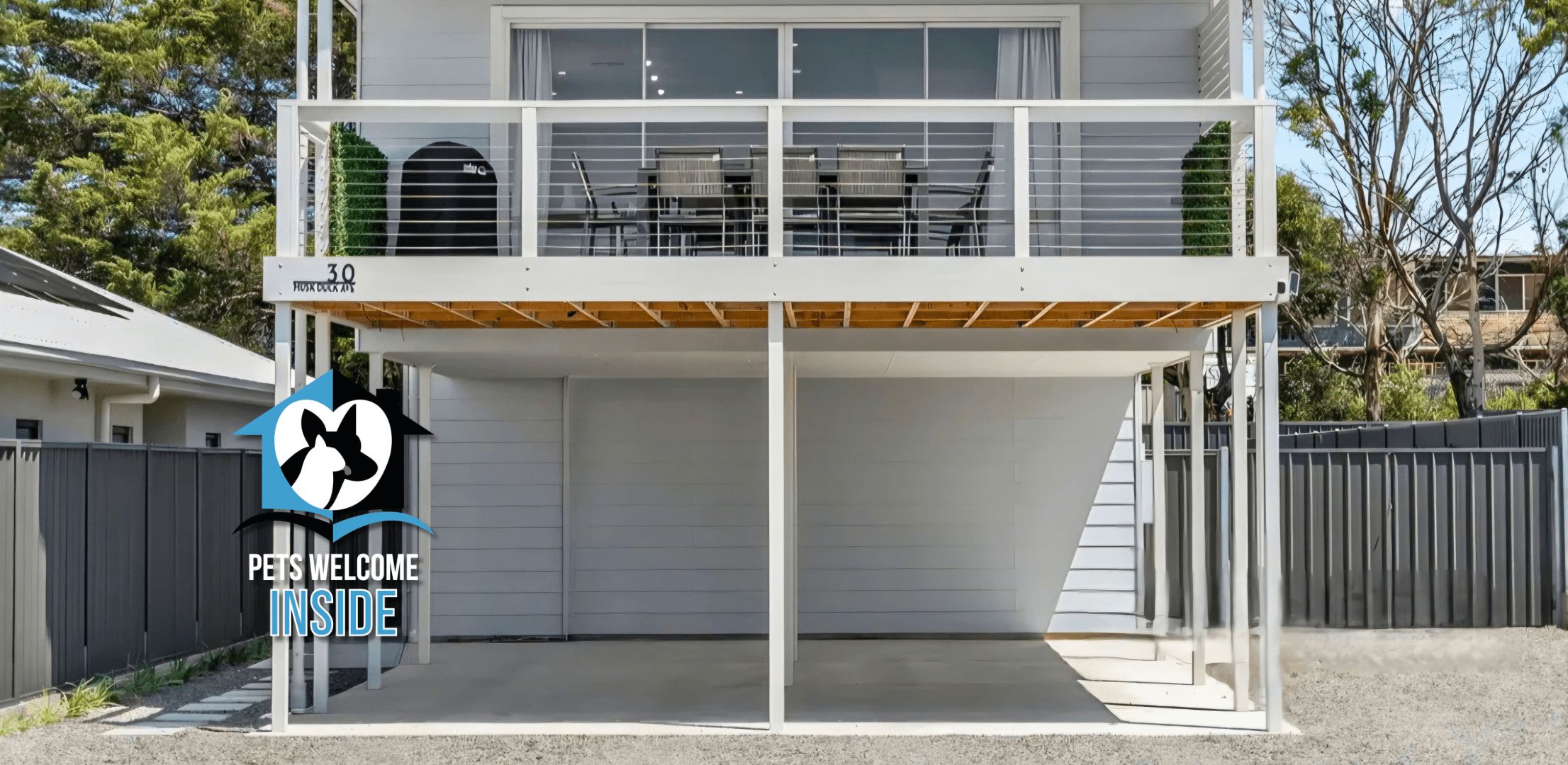 A two-story building with a covered outdoor area and a logo indicating pet-friendly accommodation.