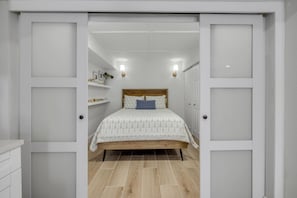 Ein Schlafzimmer mit einem hölzernen Bett, weißen Wänden und einer weißen Decke.