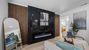 Un salon moderne avec une cheminée, un grand miroir et un canapé.