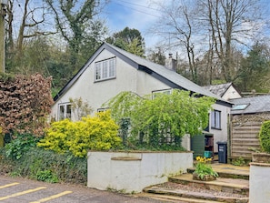 A white house with a gabled roof, surrounded by greenery and a paved driveway. - The Coach House, Dulverton (Dulverton)