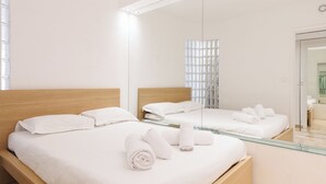 A modern hotel room with two beds, a large mirror, and a glass partition. - Upstays Elegant 1BR Gray d'Albion 2min from Palais (Cannes)