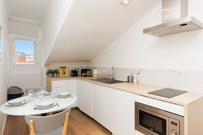 Eine kompakte Küche mit Esstisch, Backofen und Fenster mit Blick.