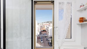 Una habitación con balcón, vista a la calle y una zona de cocina.