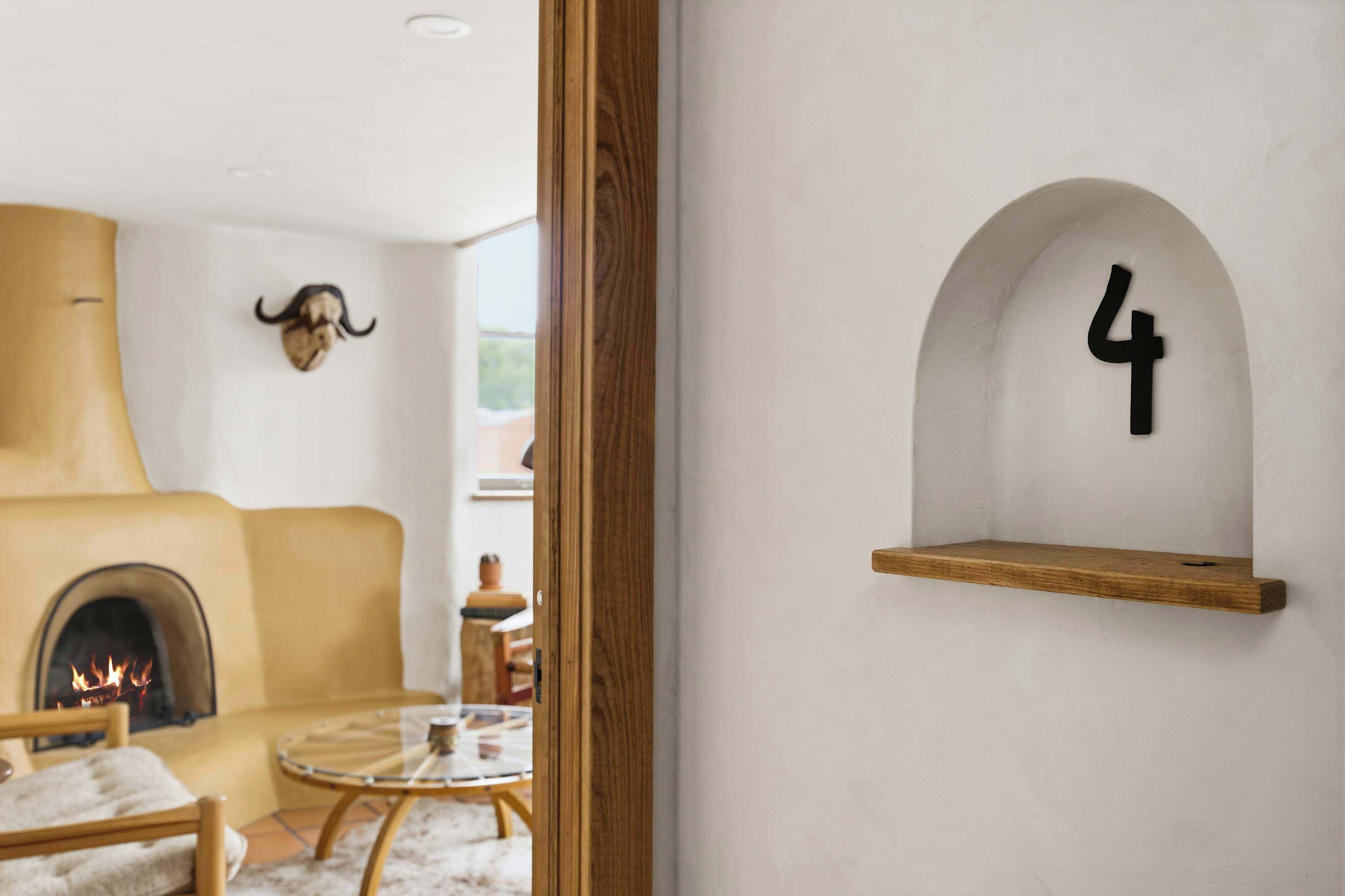 Un interior moderno con chimenea, cabeza de animal montada y estante número 4.