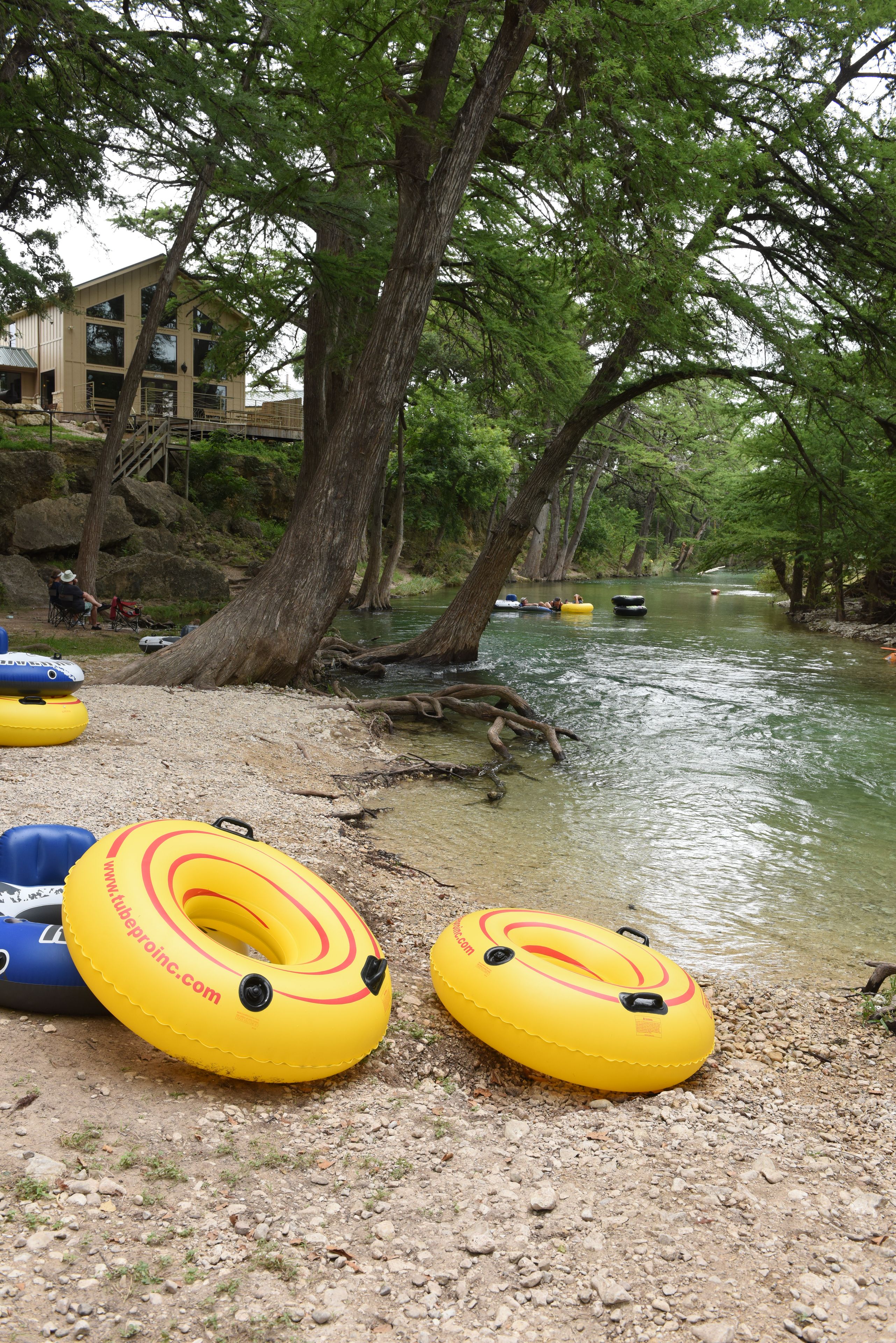 A riverside area with inflatable tubes and a building in the background.