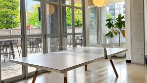 A modern office space with large windows, a long table, and hanging pendant lights. - Bay View Designer 2BR · Best Location with Balcony, Gym, and Terrace · Sleeps 6 (Milwaukee)