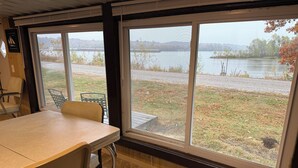 A room with a large window, a table, and two chairs.