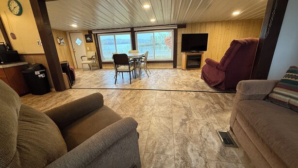 A spacious living area with a dining table and chairs, a television, and a fireplace.