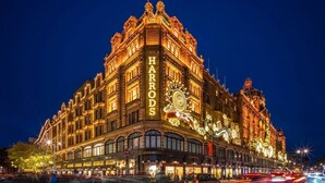 En historisk byggnad med utsmyckad arkitektur och upplyst skyltning, troligen ett hotell eller ett välkänt landmärke.