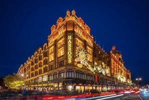 Ein historisches Gebäude mit aufwendiger Architektur und beleuchteter Beschilderung, wahrscheinlich ein Hotel oder ein Wahrzeichen.