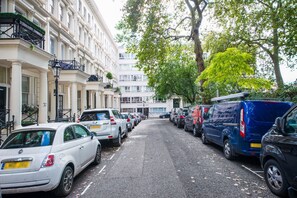 Eine Straße mit parkenden Autos und Gebäuden mit Balkonen.