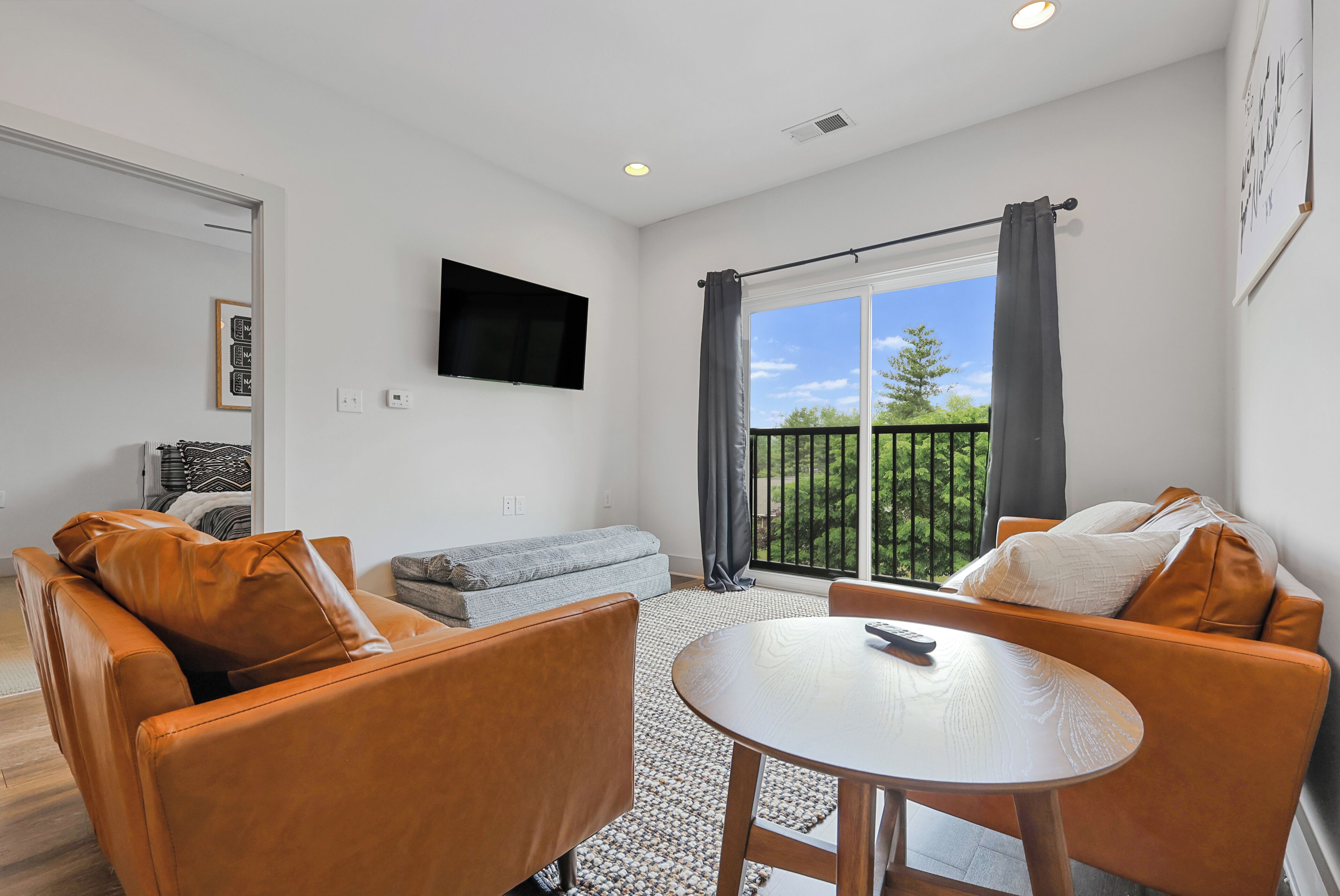 A modern living room with a sofa, armchair, and a small table.
