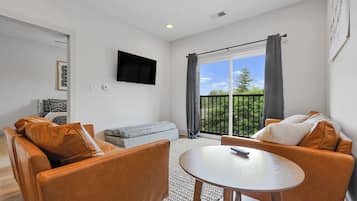 A modern living room with a sofa, armchair, and a small table.