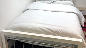 A single bed with white bedding in a room with plain white walls and a visible radiator. - Large StudioFlat in heart of Camden market (London)