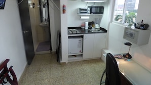 A compact kitchen with a microwave, toaster, and coffee maker. A small refrigerator is visible, and a window provides natural light. - Private  1-bedroom studio/efficiency safest location in Panama City: Walk to all (Panamá)