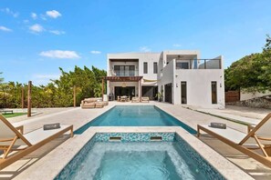 A modern two-story house with a swimming pool, outdoor seating, and a patio area. - Long Bay Villa: Pool, Jacuzzi, Near Beach (Long Bay Hills)
