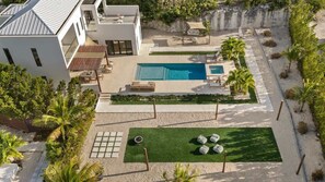 A modern house with a swimming pool, outdoor seating, and a well-maintained lawn. - Long Bay Villa: Pool, Jacuzzi, Near Beach (Long Bay Hills)