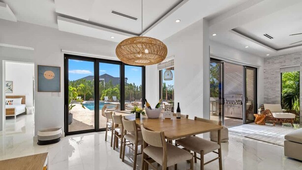 Un comedor moderno con una mesa grande, sillas y una lámpara colgante.