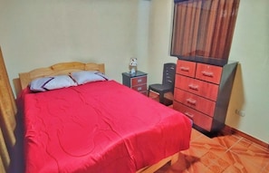 A bedroom with a bed, a nightstand, a dresser, and a mirror. - Hospedaje Jardin Rustico( A Refuge of Mud, Firewood and Peace) (Huaraz)