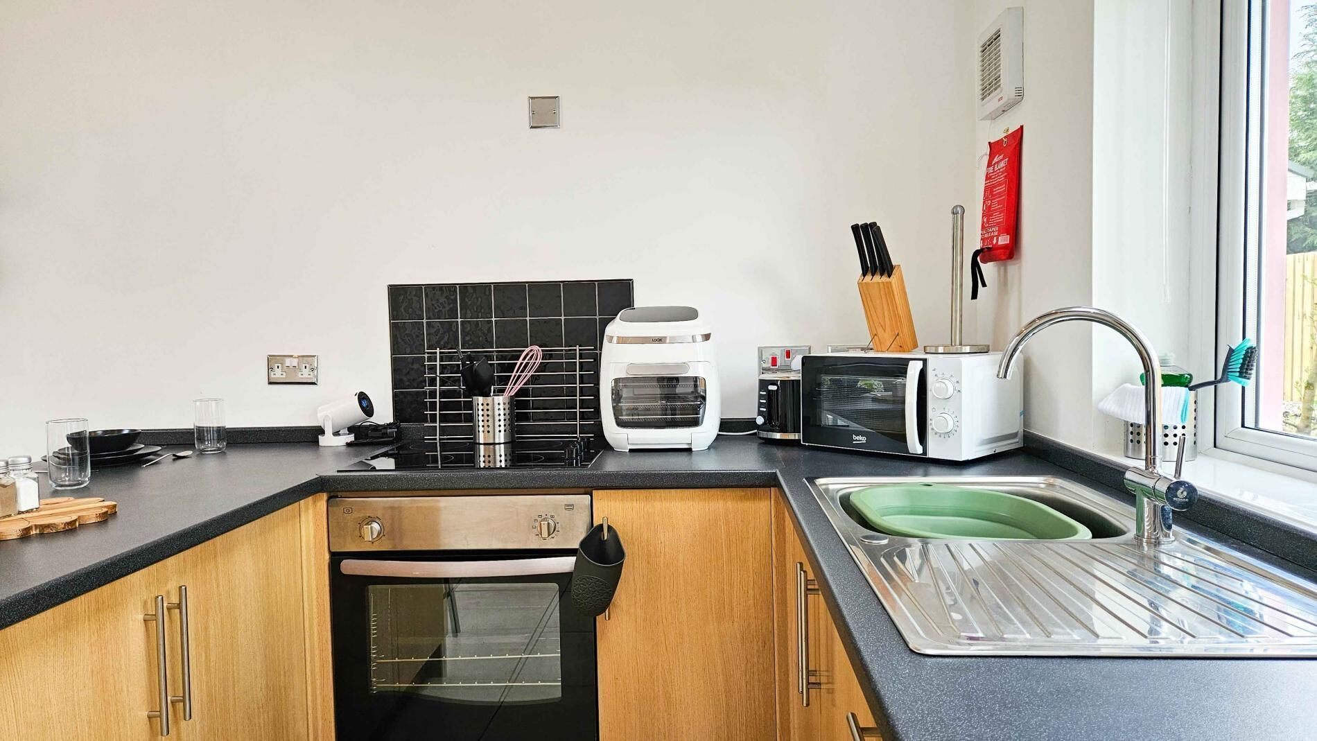 Eine moderne Küche mit Backofen, Toaster, Wasserkocher und Spüle.