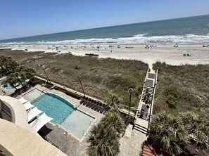 A pool area with a view of the beach and ocean. - Oceanfront Condo w/ Pools & Lazy River (North Myrtle Beach)