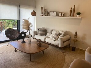 A modern living room with a sofa, coffee table, and decorative items. - Aura Jungle Oasis (Tulum)