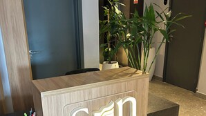 A reception desk with a wooden finish and a sign that reads "son". - Melhores Flats - Exclusividade vista mar (Cabedelo)